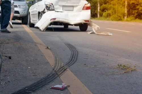 A white car with rear end damage after a rear end collision.