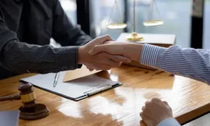 A personal injury lawyer shaking a client's hand after coming to an agreement on how to approach a case.