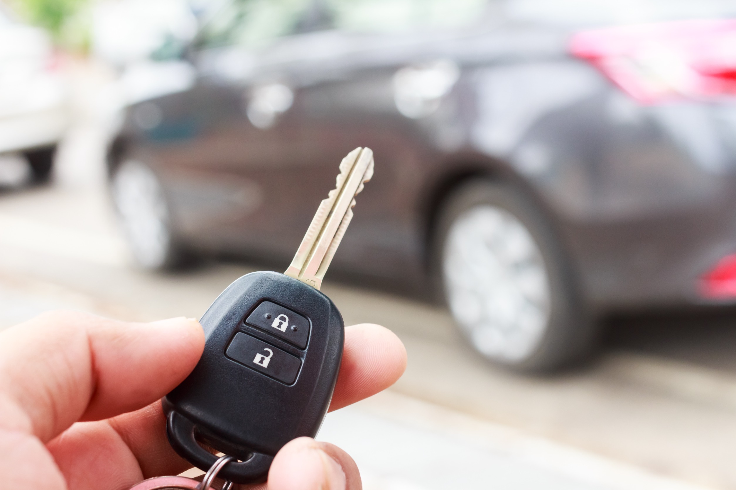 person using a key fob to unlock their rental car