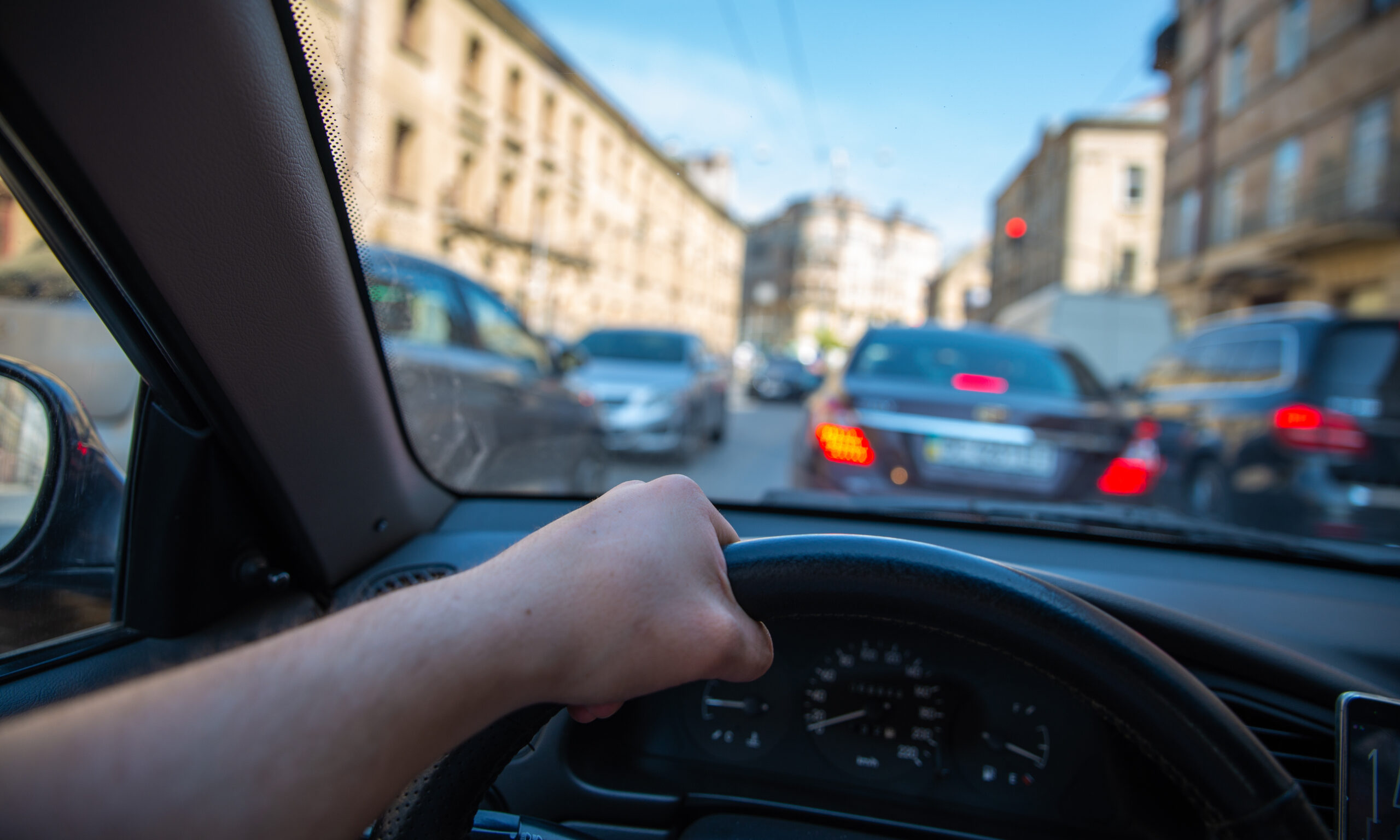 A driver's perspective of a city road while they drive in traffic.