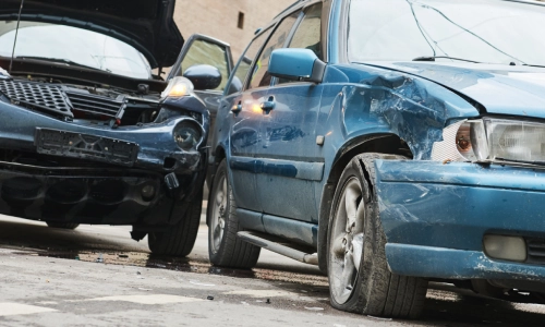 The aftermath of a sideswipe accident between two cars on a city road.