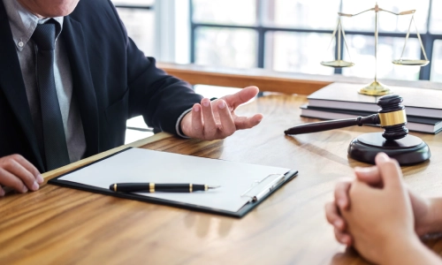 A golf cart accident lawyer speaking with a client in his office and offering advice for a case.