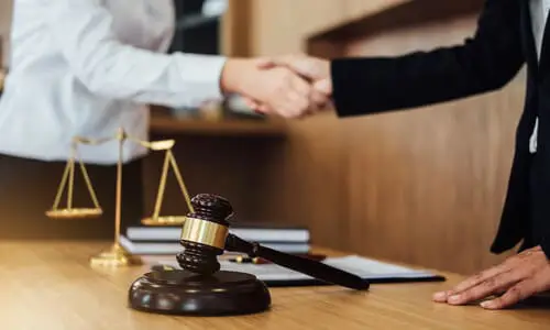 A personal injury lawyer shaking a client's hand after agreeing to work together.